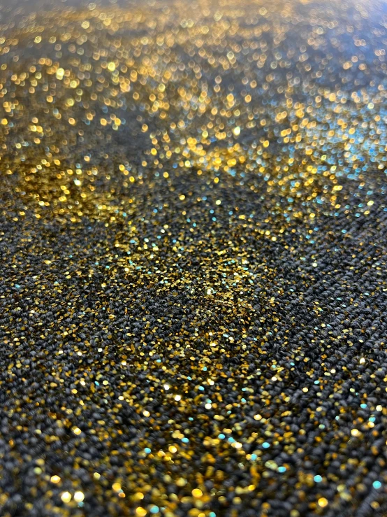 a close up of a shiny surface, by Eva Švankmajerová, reddit, black and gold, sugar sprinkled, ✨🕌🌙, grey and gold color palette