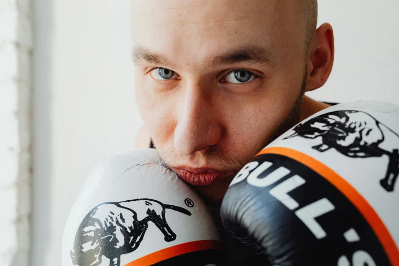 a close up of a person wearing boxing gloves, a portrait, by Emma Andijewska, pexels contest winner, bauhaus, pitbull, low quality photo, vitaly bugarov, hand on his cheek