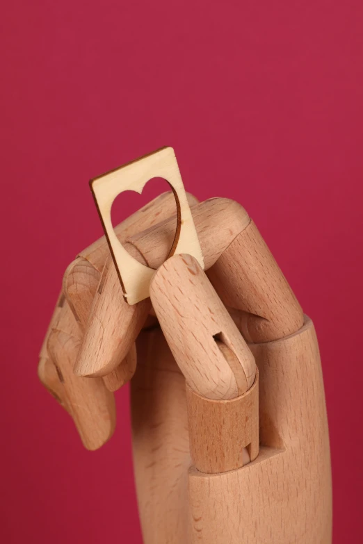 a hand holding a piece of wood with a heart cut out of it, inspired by Okada Hanko, product display photograph, monocle, rectangle, holding gold