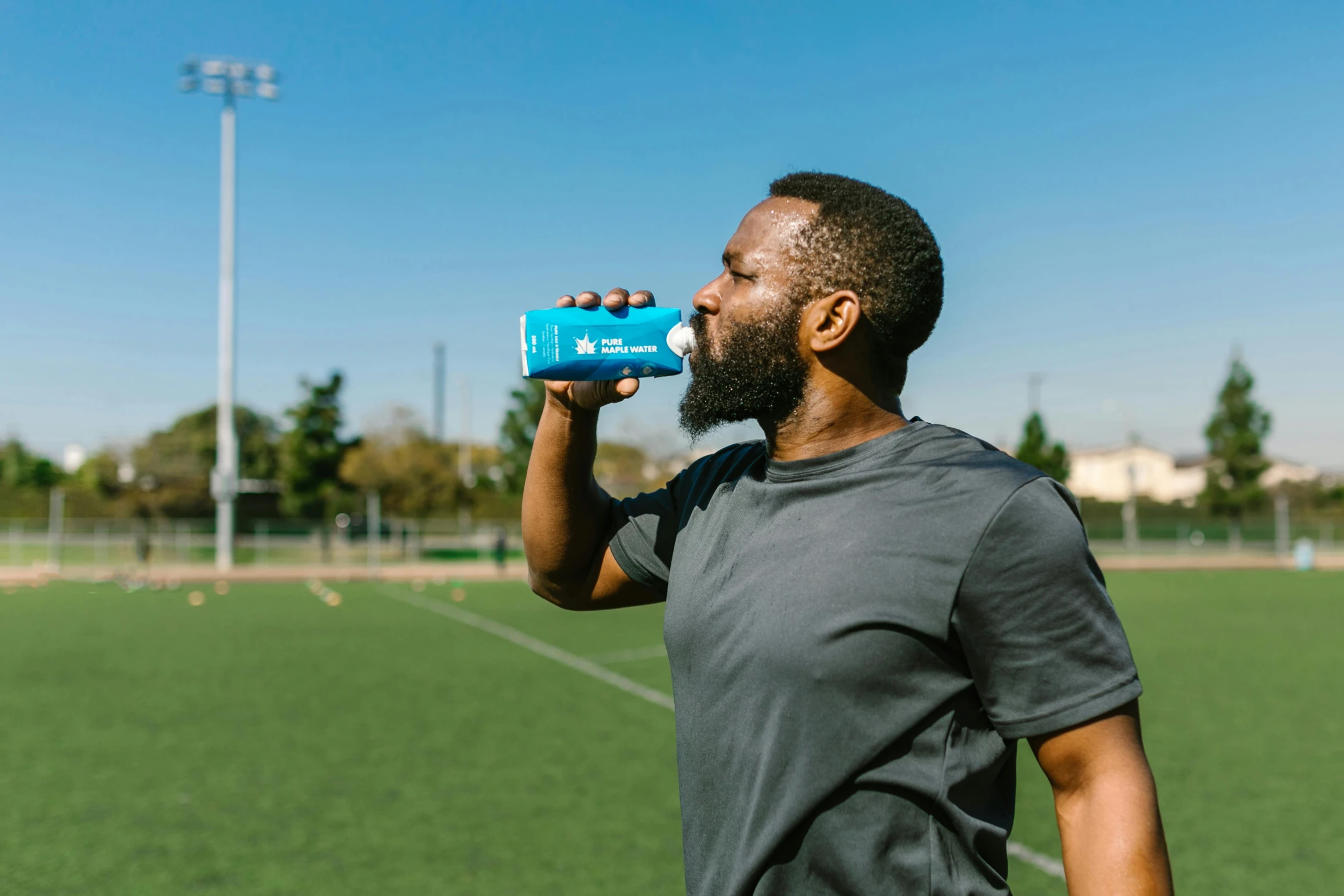 a man drinking from a water bottle on a soccer field, mc ride, profile image, product shot, instagram post