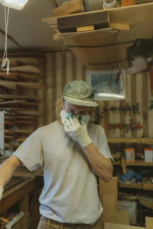 a man standing in a wood shop talking on a cell phone, reddit, process art, surgical mask covering mouth, tony hawk crying, still from a nature documentary, thumbnail