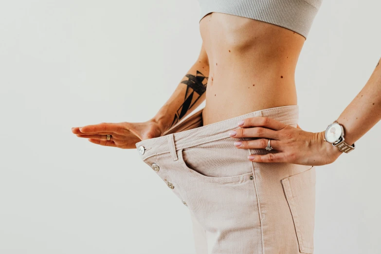 a woman standing with her hands in her pockets, a tattoo, trending on pexels, folds of belly flab, gigantic scale, ad image, hyperdetailed