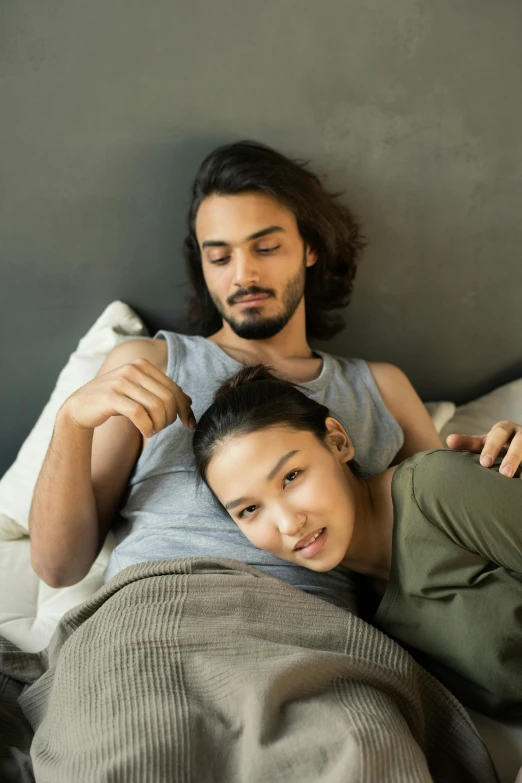 a man and woman laying in bed next to each other, trending on pexels, renaissance, half asian, supportive, looking her shoulder, grey