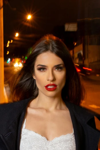 a woman standing on a city street at night, by Luis Miranda, both have red lips, meni chatzipanagiotou, promotional image, chile
