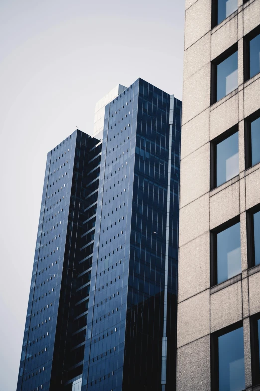 a couple of tall buildings next to each other, a photo, unsplash, tall obsidian architecture, glossy surface, low quality photo, 2000s photo