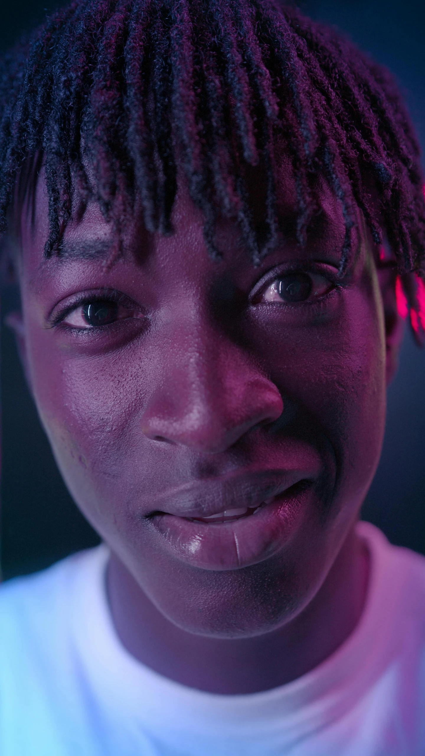 a close up of a person with dreadlocks, an album cover, pexels contest winner, hyperrealism, black teenage boy, purple lights, self - satisfied smirk, androgynous person