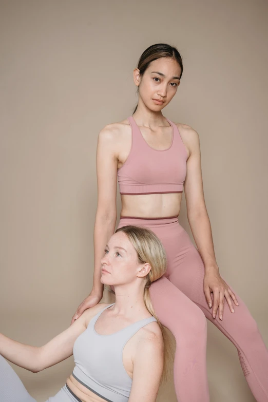 two women sitting on top of each other, inspired by Wang Duo, trending on pexels, renaissance, sports bra, minimal pink palette, low quality photo, default pose neutral expression