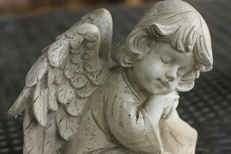 a statue of an angel sitting on a bench, inspired by Marie Angel, concrete art, medium closeup, putti, grey, medium angle