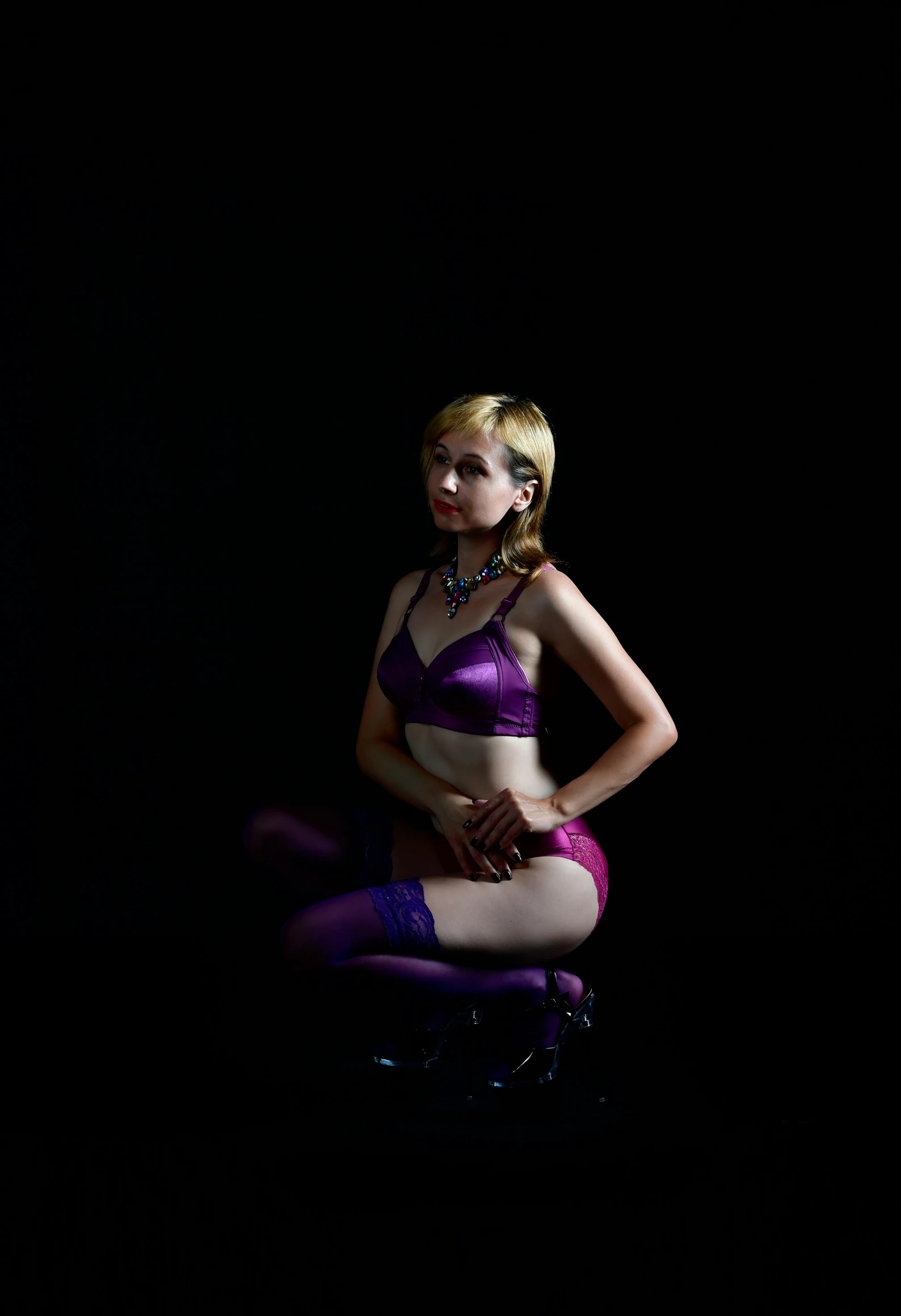 a woman sitting on top of a chair in a dark room, inspired by Cindy Sherman, ((purple)), glamourous cosplay, gwen stacy, high quality photo
