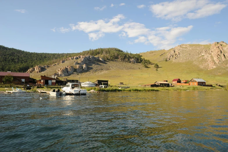 a group of boats floating on top of a lake, hurufiyya, log homes, wind river valley, exterior photo