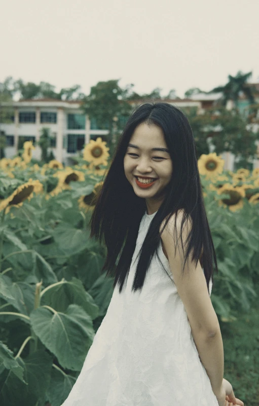 a woman standing in a field of sunflowers, inspired by Xie Sun, pexels contest winner, young cute wan asian face, laughing, grainy low quality, student