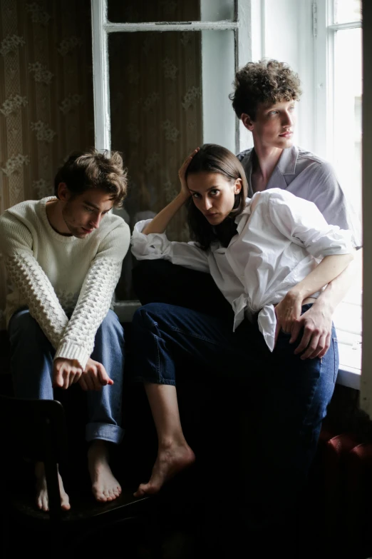 a group of people sitting on top of a couch, a portrait, by Anita Malfatti, unsplash, white russian clothes, sad look, tall and lanky skinny, wearing a light shirt