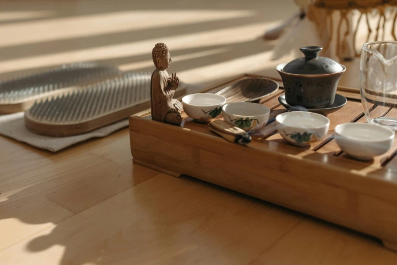 a wooden tray sitting on top of a wooden table, inspired by Tani Bunchō, trending on unsplash, robed figures sat around a table, tea, figure meditating close shot, miniature product photo