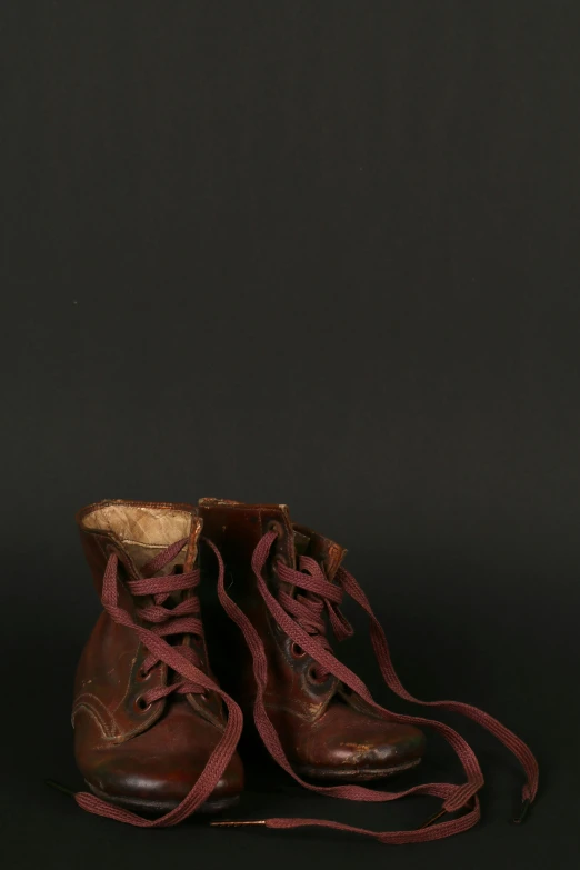 a pair of brown boots sitting on top of a black surface, by Alison Geissler, museum quality photo, - 8, reds, early 2 0 th century