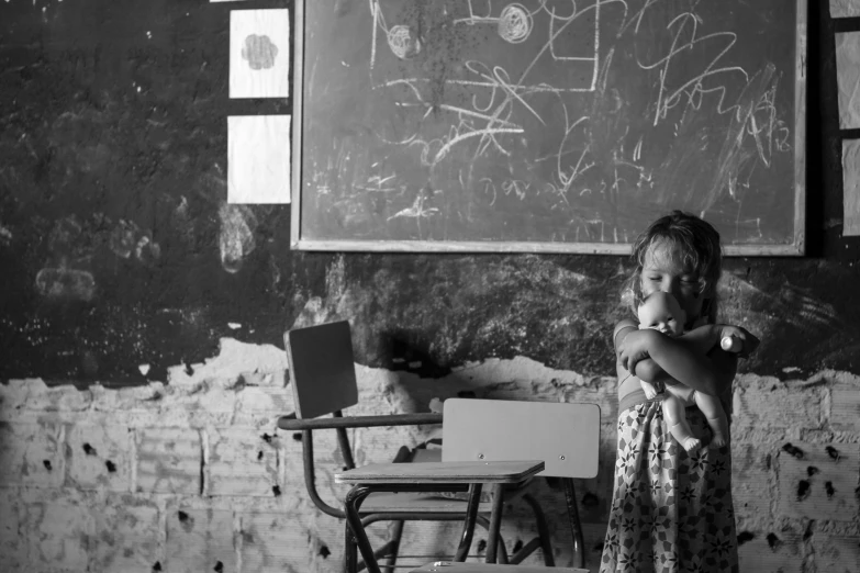 a little girl standing in front of a blackboard, a black and white photo, flickr, quito school, an abandoned, sitting in the classroom, favelas, full width