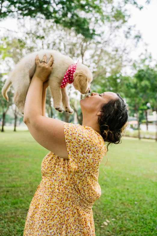 a woman holding a puppy up in the air, by Nicolette Macnamara, happening, at a park, profile image, square, australian