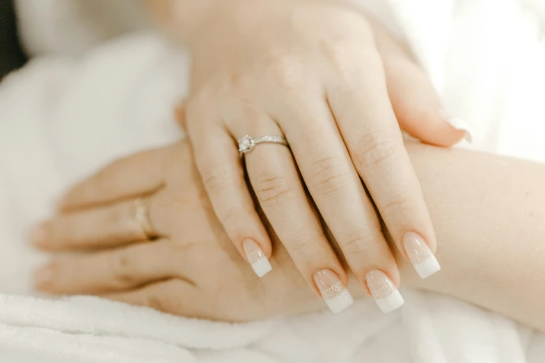 a close up of a person holding a wedding ring, trending on pexels, nail art, silver，ivory, animation, white gloves