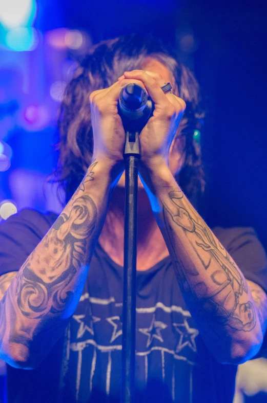 a man holding a microphone up to his face, a tattoo, pexels contest winner, symbolism, dave grohl, ville valo, photograph of a sleeve tattoo, profile image