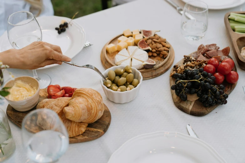 a table topped with plates of food and glasses of wine, pexels contest winner, eating a cheese platter, french provincial furniture, al fresco, slightly minimal