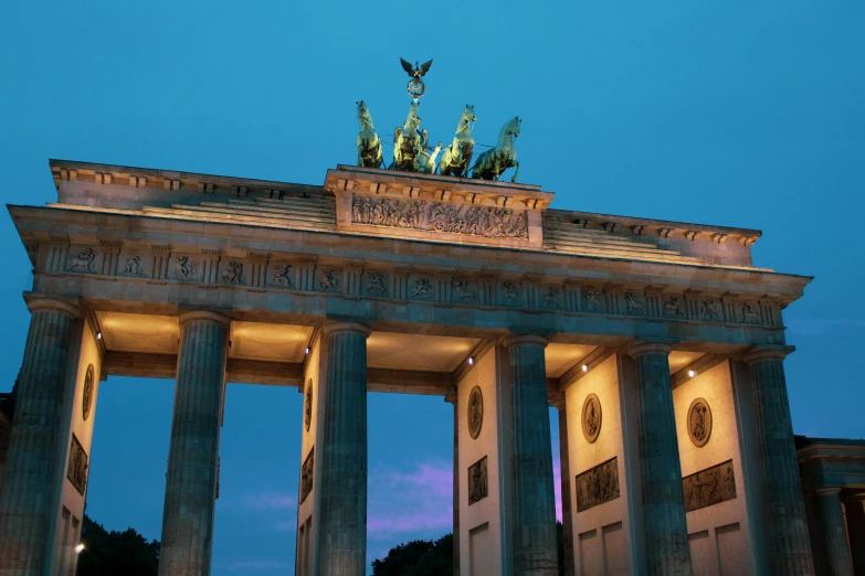 a very tall building with some statues on top of it, pexels contest winner, berlin secession, avatar image, an archway, nights, german chancellor