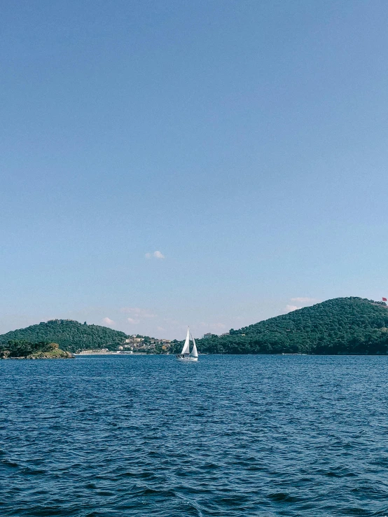 a sailboat in the middle of a large body of water, croatian coastline, slide show, julia sarda, clean image