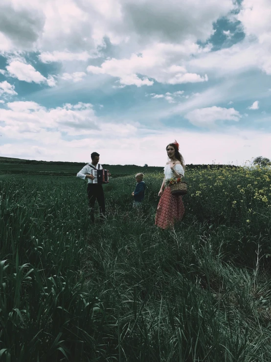 a group of people standing on top of a lush green field, an album cover, unsplash, german romanticism, ukrainian national costume, profile image, iphone photo