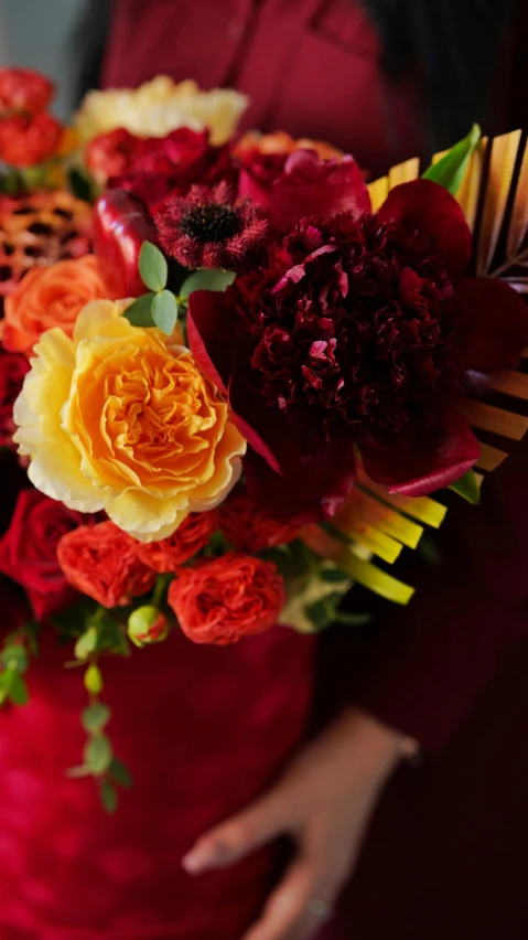 a woman in a red dress holding a bouquet of flowers, dark oranges reds and yellows, detail shot, velvet, swirling flowers