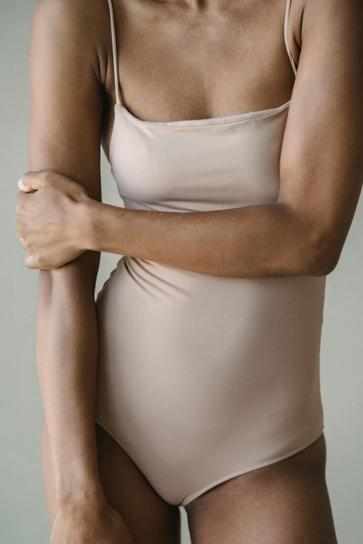 a woman in a bodysuit posing for a picture, by Nina Hamnett, unsplash, renaissance, muted arm colors, no - text no - logo, smooth tan skin, 3/4 front view
