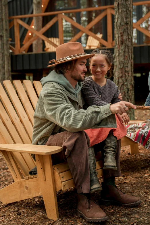 a group of people sitting on top of a wooden bench, mackenzie foy, will graham, ecovillage, in a comfortable chair