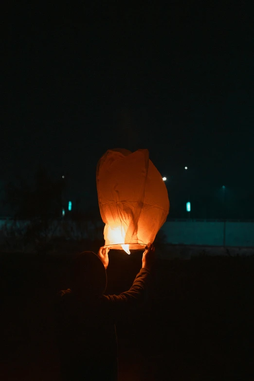 a person holding a lantern in the dark, balloon, square, low quality photograph, fires