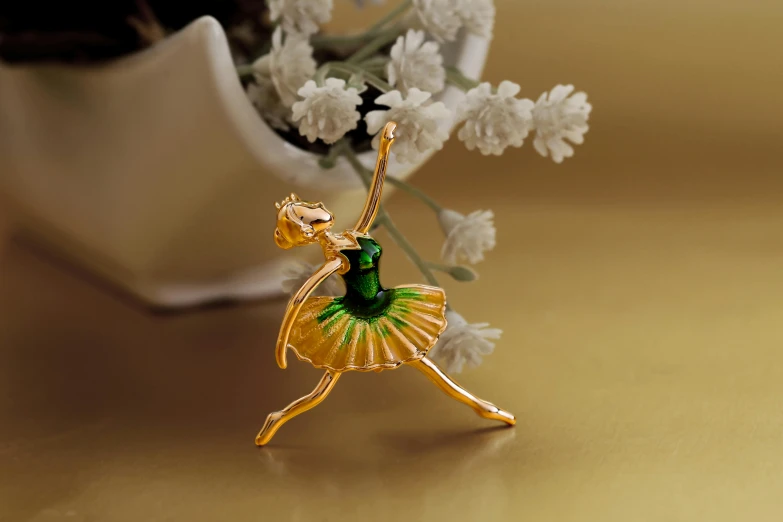 a close up of a figurine of a ballerina, inspired by Elizabeth Polunin, arabesque, green gold, enamel, product introduction photo, pins