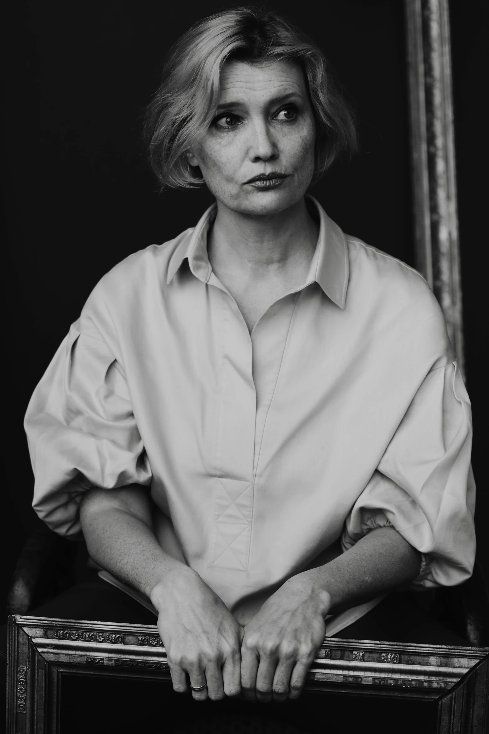 a black and white photo of a woman in a chair, inspired by August Sander, unsplash, photorealism, girl with short white hair, in style of valentin serov, wearing a blouse, clothed.1990s