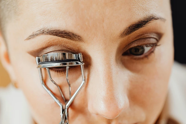 a close up of a person holding a pair of scissors, dark brown eyes and eyelashes, thumbnail, makeup, eyes rolled back