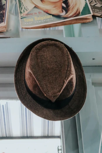 a hat sitting on top of a window sill, inspired by Joseph Beuys, unsplash, close up head shot, brown:-2, party hats, multiple stories