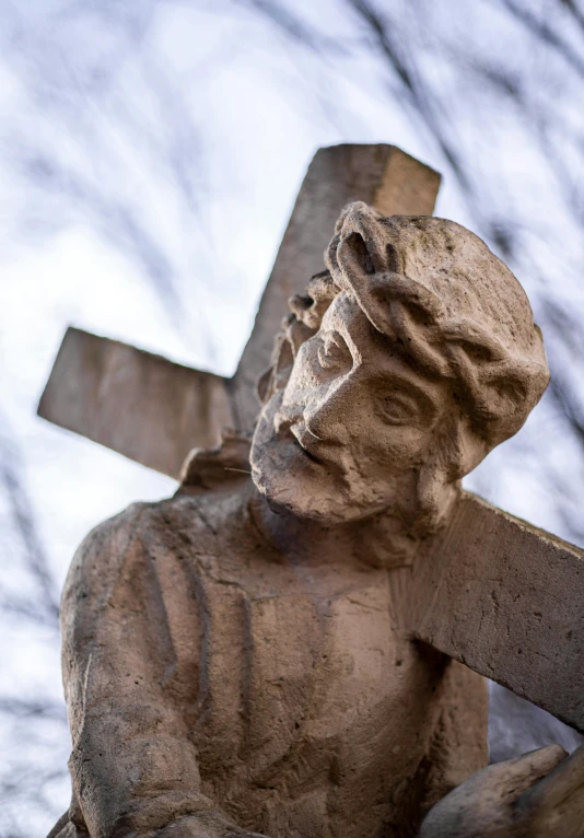 a statue of a man carrying a cross, inspired by Jesús Mari Lazkano, unsplash, close - up of face, cross-eyed, cementary, фото девушка курит