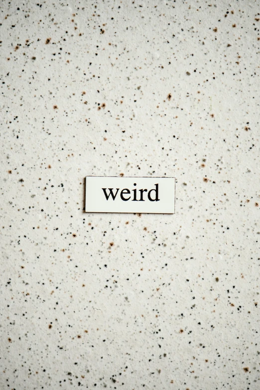 a white sign with the word weird on it, an album cover, inspired by Cerith Wyn Evans, trending on pexels, speckled, poop, recessed, nerd