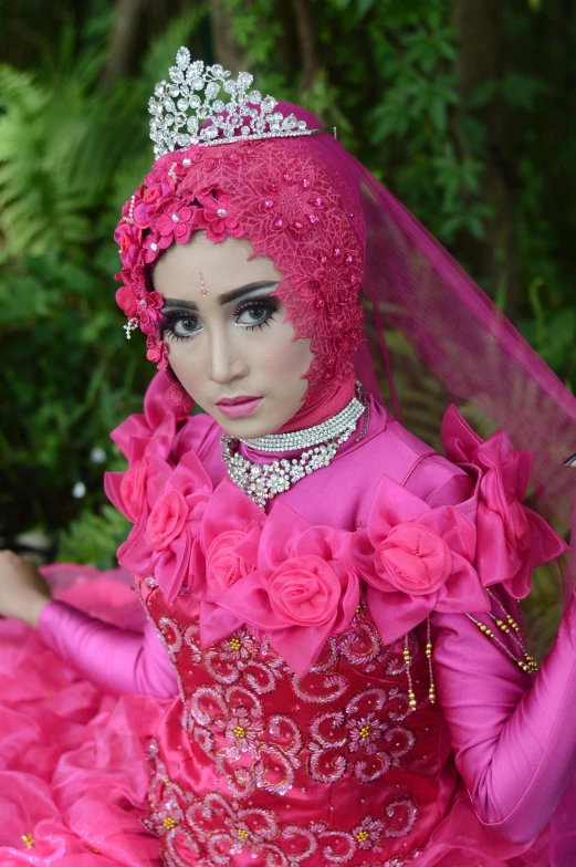 a woman in a pink dress posing for a picture, a picture, by Basuki Abdullah, flickr, hurufiyya, headpiecehigh quality, with professional makeup, square, wedding photo