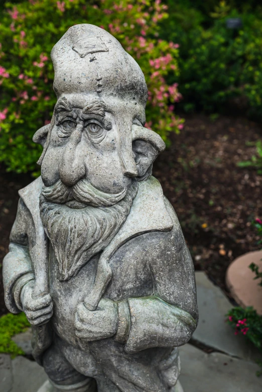 a statue of a gnome in a garden, by Bernie D’Andrea, concrete art, skeptical expression, long trunk holding a wand, zoomed out portrait of a duke, quaint