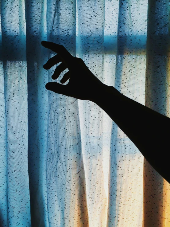 a silhouette of a person reaching out of a window, an album cover, inspired by Elsa Bleda, unsplash, magical realism, curtains, hand gesture, snapchat photo, ( ( theatrical ) )