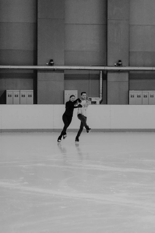a couple of people skating on top of an ice rink, a black and white photo, arabesque, indoor, 8k 50mm iso 10, instagram picture, [ zero - gravity ]!!
