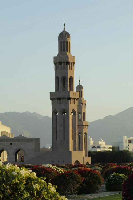 a tall clock tower sitting in the middle of a lush green field, oman, chimneys on buildings, cathedral!!!!!, delightful