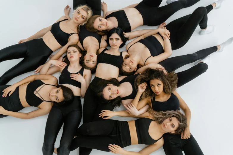 a group of women laying on top of each other, inspired by Vanessa Beecroft, trending on pexels, renaissance, wearing black tight clothing, manuka, group photo, female dancer