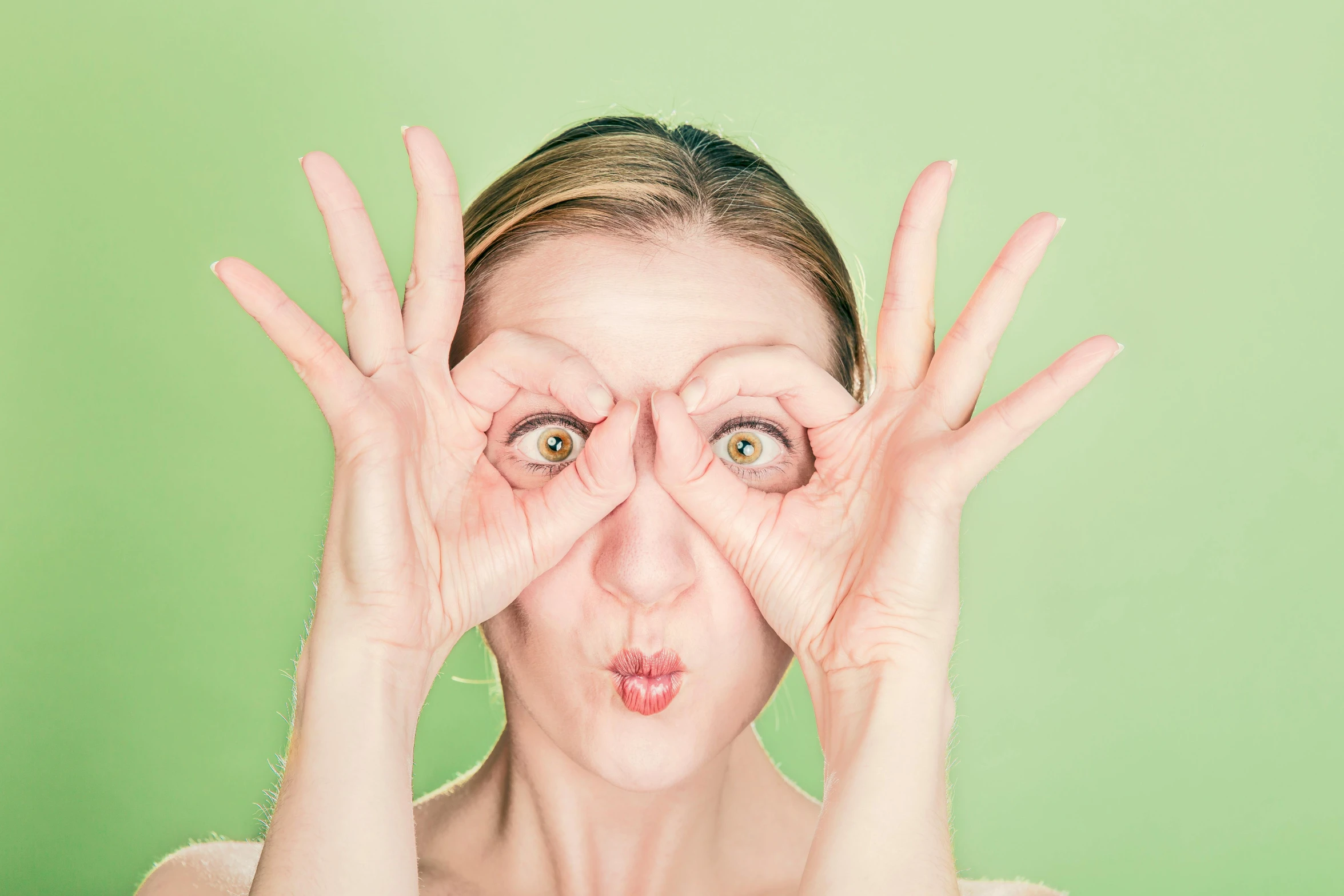 a woman making a funny face with her hands, inspired by Elke Vogelsang, mint green eyes, stockphoto, eyes!, multiple eyes