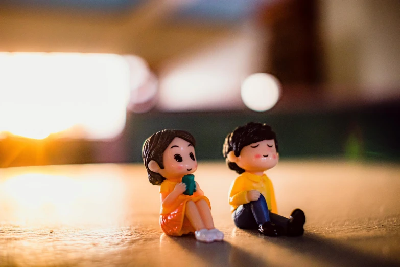 a couple of figurines sitting next to each other, by Lilia Alvarado, pexels contest winner, childhood friend vibes, brightly lit, instagram picture, cartoon still