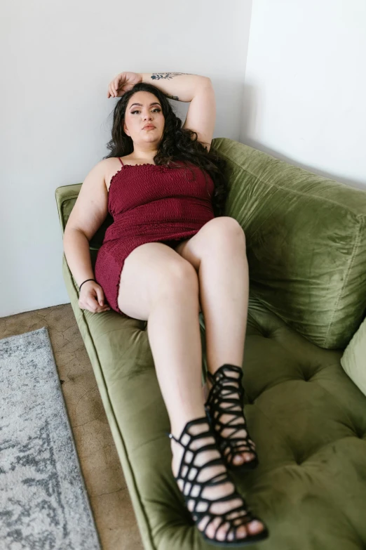a woman in a red dress laying on a green couch, instagram, thick thighs, wearing a dark dress, on a pale background, fullbody photo