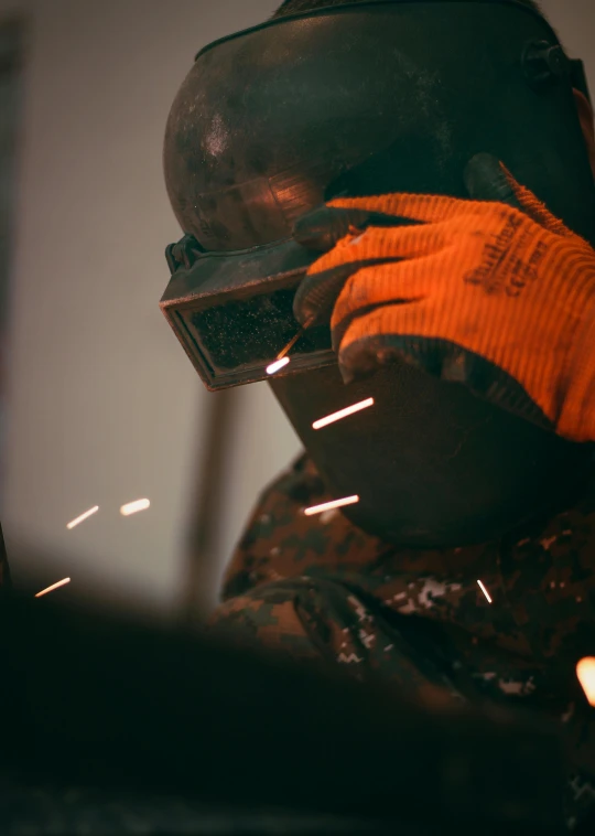 a welder working on a piece of metal, a portrait, pexels contest winner, arbeitsrat für kunst, orange balaclava, grainy, brown, thumbnail