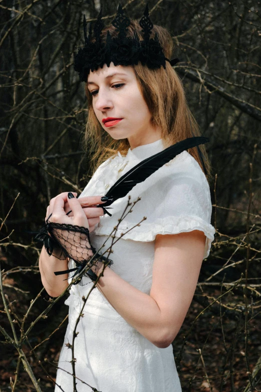 a woman in a white dress holding a camera, an album cover, inspired by Cindy Sherman, unsplash, renaissance, black feathers, forest punk, holding bat, white elbow gloves