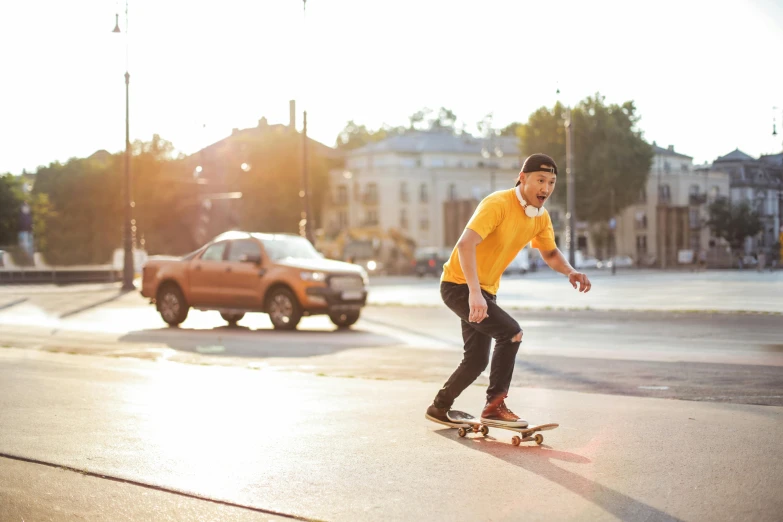 a man riding a skateboard down a street, a picture, gold, nice afternoon lighting, wearing a modern yellow tshirt, andrei ryabovichev