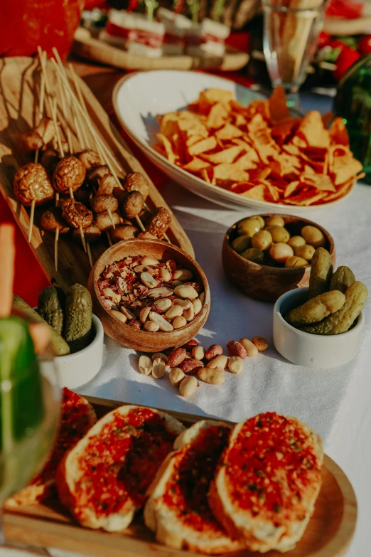 a table topped with lots of different types of food, close up details, sunset view, mediterranean features, waist up