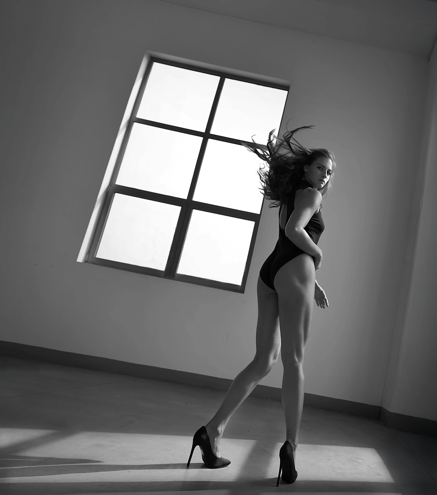 a black and white photo of a woman in high heels, inspired by Helmut Newton, big windows, soft lighting |, dancer, nina dobrev